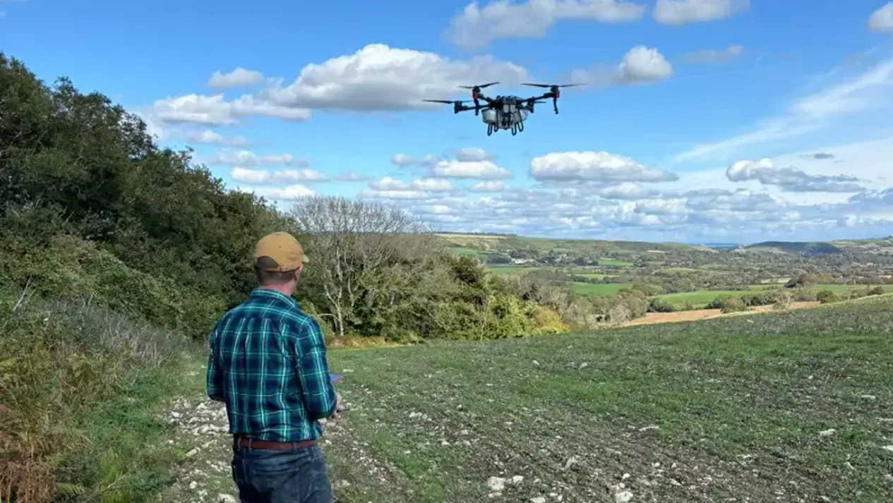 Ben spraying crops with an agricultural drone on a clear spring afternoon